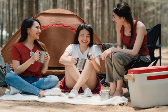 Group of young Asian friends camping or picnic together in fores